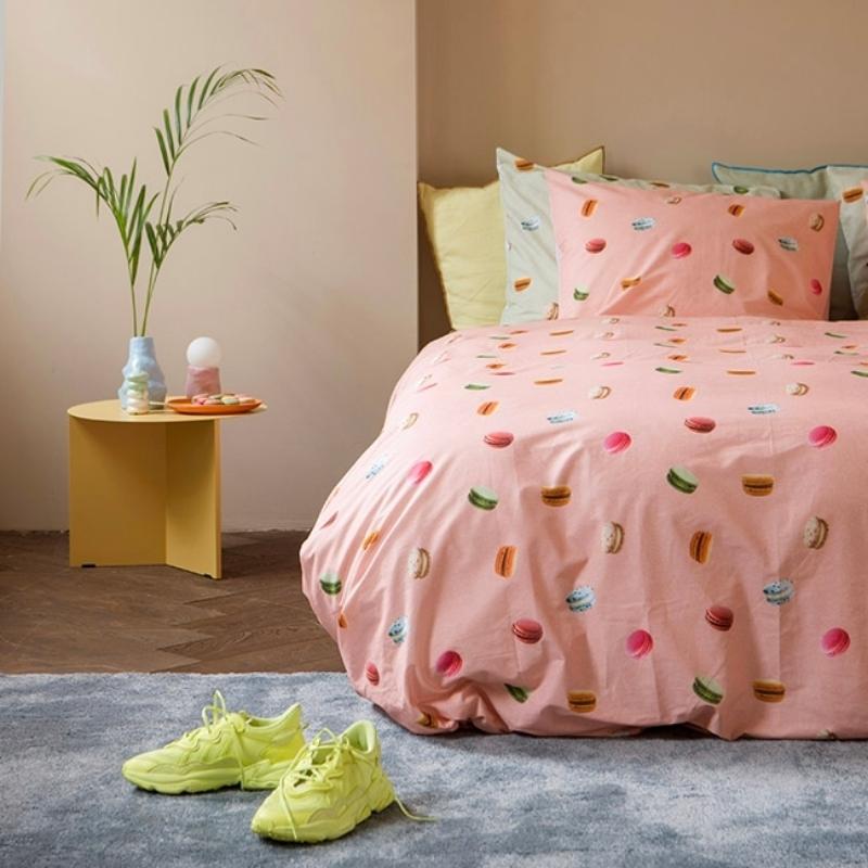 Roze dekbedovertrek met afbeeldingen van macron's in moderne slaapkamer