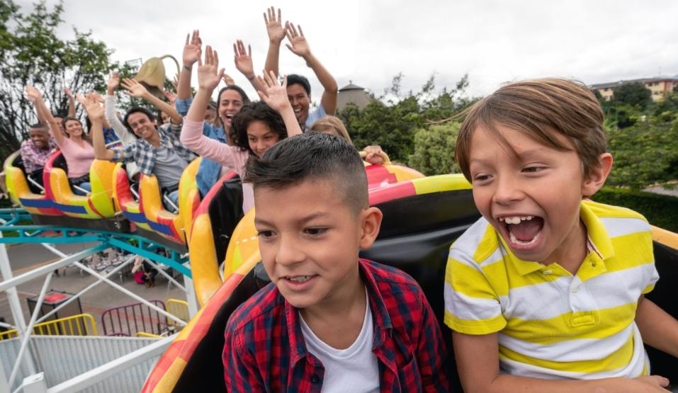 Kinderen met tickets voor pretpark in achtbaan