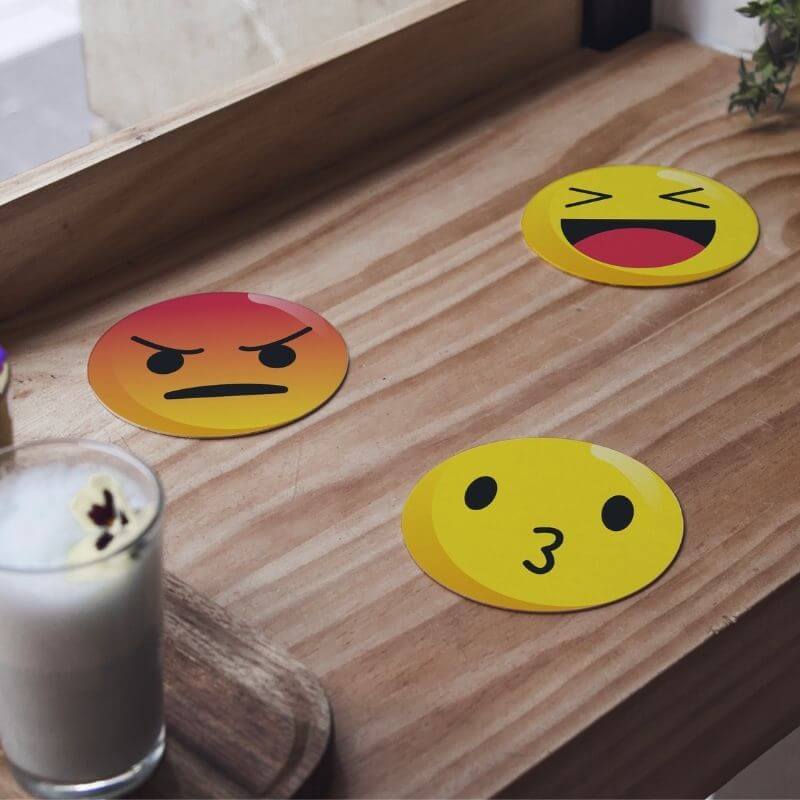 Emoji onderzetters voor glazen op een keukentafel