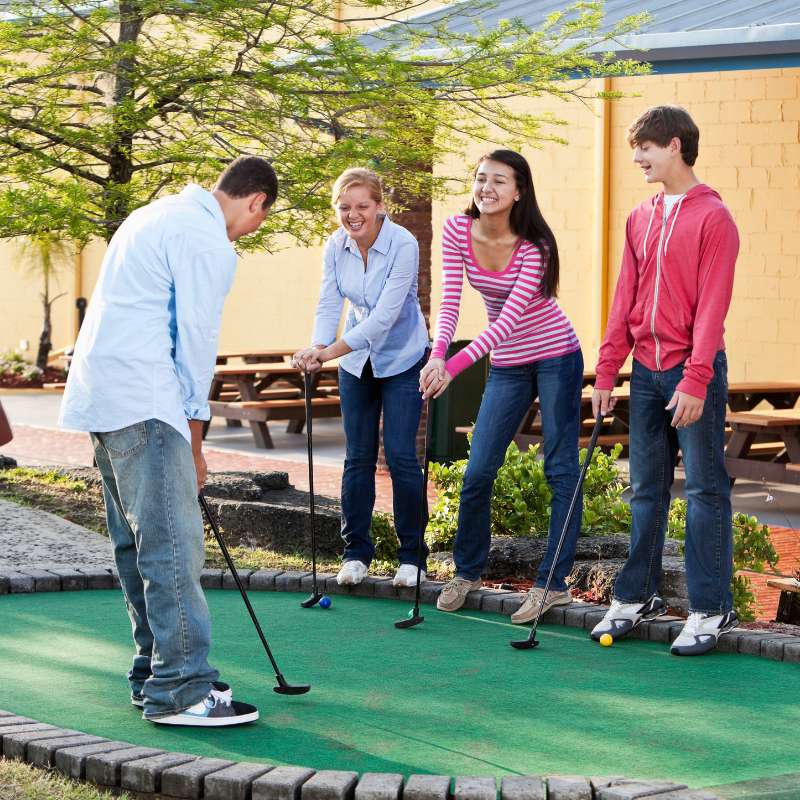 Tieners op een mini-golfbaan tijdens een dagje uit